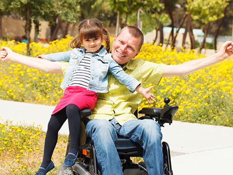 Dad in wheelchair playing with daughter