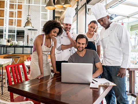 Waitress, business owner and chef look over menu selections for a busy restaurant