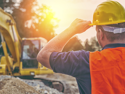 Construction worker in hard hat looking over job site