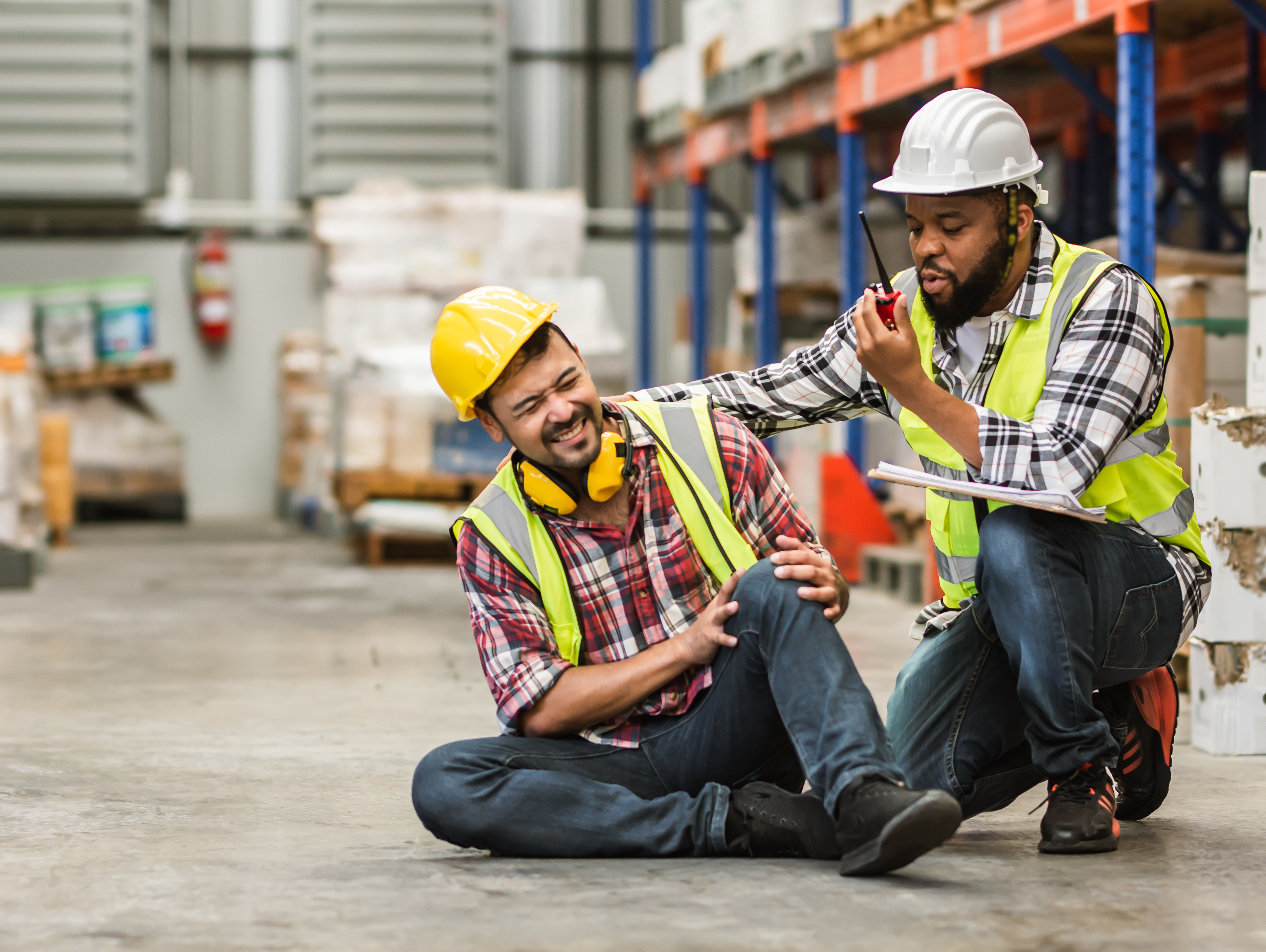 Warehouse worker radioing for help for injured co-worker