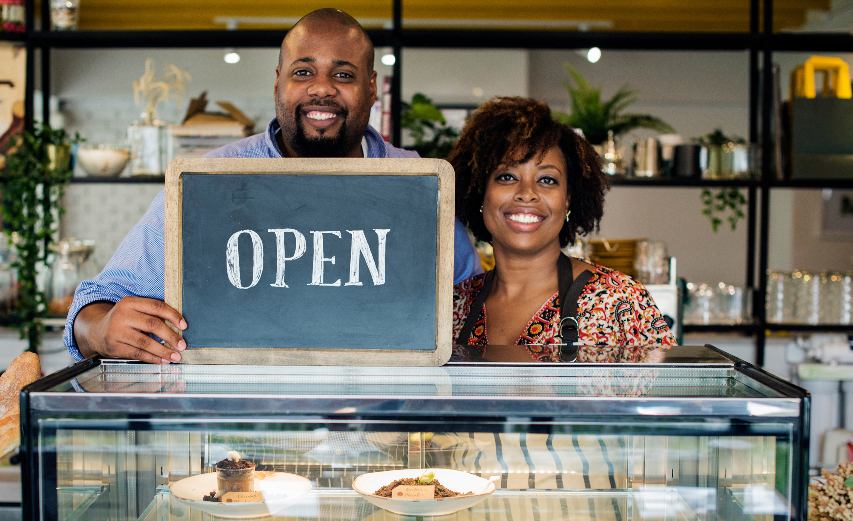 Shop Owners with Open Sign