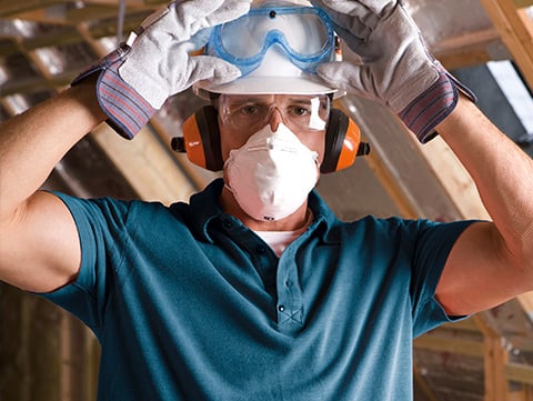 Worker in protective gear including gloves, mask and googles