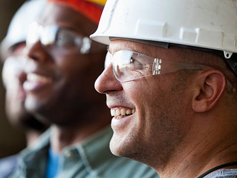 Group of men in construction hats and safety glasses
