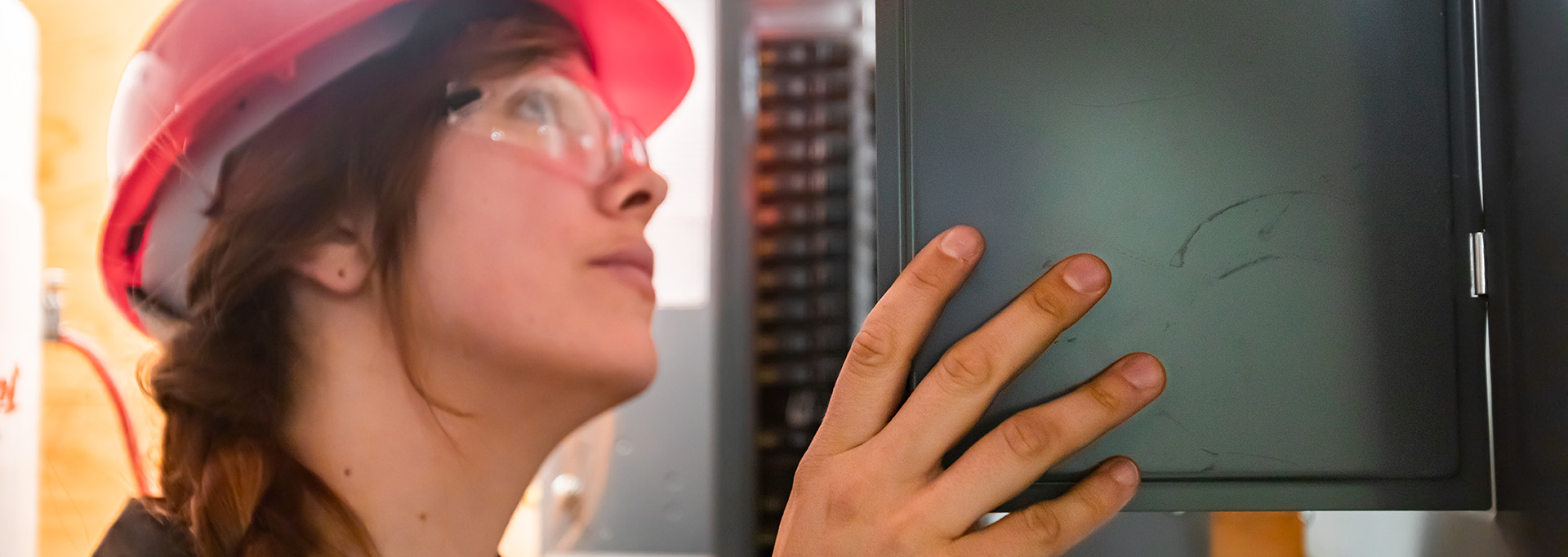 Female electrician reviewing an electrical panels